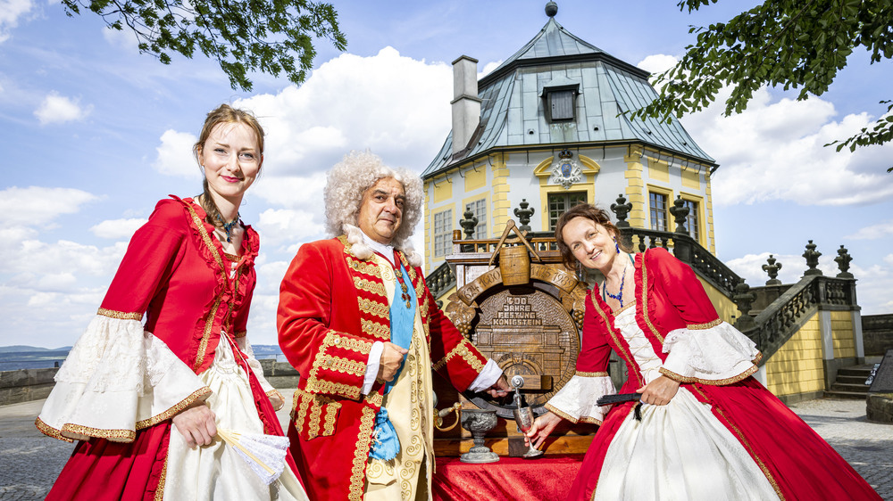 August der Starke (Uwe Müller) und zwei Hofdamen mit Modell des Riesenweinfasses vor der Friedrichsburg, Foto:Marko Förster/ Festung Königstein