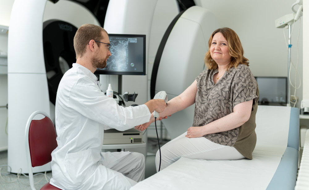 Dr. Frank Gellrich untersucht die an schwarzem Hautkrebs erkrankte Patientin Mandy Schimm am Uniklinikum Dresden regelmäßig mit einem Laserscanmikroskop. Foto: UKD/Kirsten Lassig