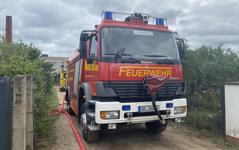 © Feuerwehr Dresden Symbolbild: Ein Tanklöschfahrzeug steht in einer Kleingartenanalage und liefert das Löschwasser zur Brandbekämpfung.