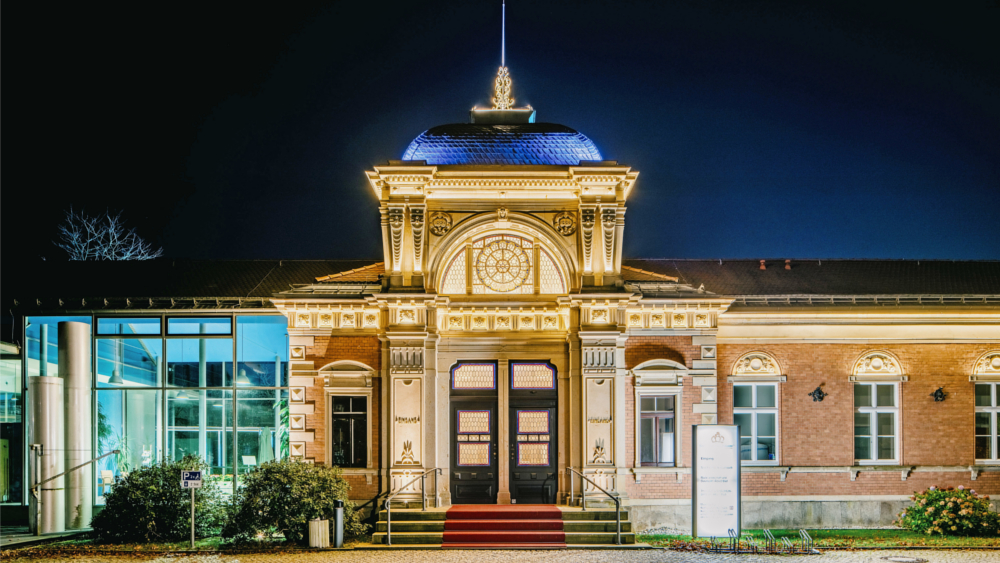 Im historischen Albert Bad in Bad Elster, hier in abendlicher Illumination, treffen Tradition und Moderne reizvoll aufeinander – in der Architektur und den Therapie- und Wohlfühlanwendungen. Foto: DJD/Sächsische Staatsbäder/Danny Otto