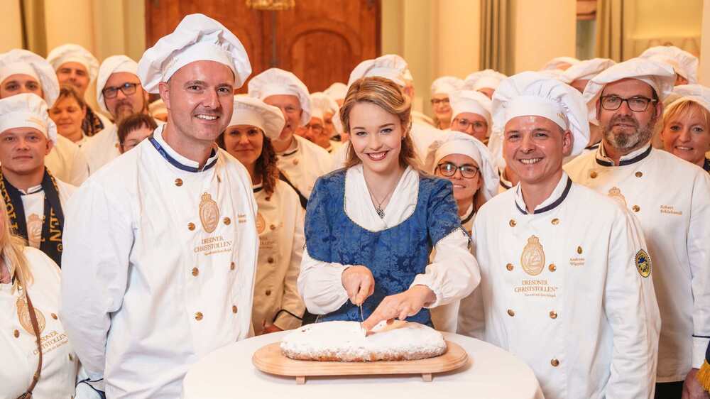 Stollenmädchen Johanna Worm mit den Mitgliedern des Schutzverbandes Dresdner Stollen. Foto: Schutzverband Dresdner Stollen/Michael Schmidt