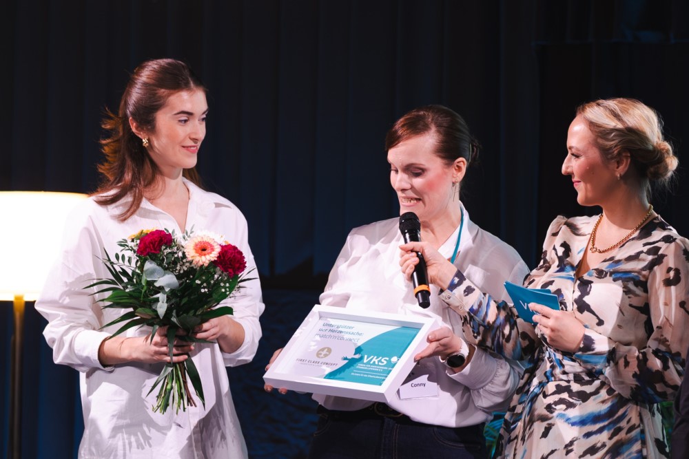 Für die First Class Concept GmbH ist der VKS e.V. eine „Herzenssache“. Projektleiterin Miriam Proschmann nimmt von Conny Berger (VKS) und Moderatorin Henriette Fee Grützner ein Dankeschön entgegen. (v.l.)    Foto: Franziska Kestel